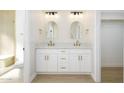 Bathroom featuring double vanity, white cabinetry, modern fixtures, and framed mirrors at 1102 W Peoria Ave # 17, Phoenix, AZ 85029