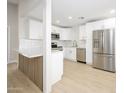 Open kitchen with white cabinets, stainless steel appliances, and modern island at 1102 W Peoria Ave # 17, Phoenix, AZ 85029