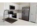Bright kitchen featuring quartz countertops, stainless steel appliances, and white cabinetry at 12586 W Amelia Ave, Avondale, AZ 85392