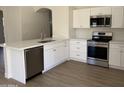 Bright kitchen featuring quartz countertops, stainless steel appliances, and new wood flooring at 12586 W Amelia Ave, Avondale, AZ 85392