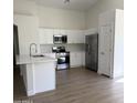 This kitchen features quartz countertops, stainless steel appliances, and new wood flooring at 12586 W Amelia Ave, Avondale, AZ 85392