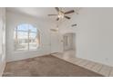 Bright living room with vaulted ceilings, a large arched window, and neutral-colored carpet and tile flooring at 1371 W Gary Dr, Chandler, AZ 85224