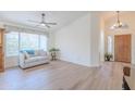 Open living room with wood floors, large windows, and a ceiling fan. Entryway visible in the background at 17293 N Ponca Way, Surprise, AZ 85374