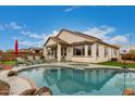 Resort-style backyard oasis with a sparkling pool, spa, and lounge area for outdoor relaxation at 17909 W Agave Rd, Goodyear, AZ 85338