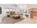 Open-concept living area featuring a comfortable leather sofa, ample natural light, and seamless kitchen access at 17909 W Agave Rd, Goodyear, AZ 85338