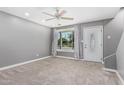 Bright living room featuring new carpet, ceiling fan, and a large window with decorative curtains at 18 E Hermosa Dr # 18, Tempe, AZ 85282