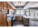 Kitchen featuring wood cabinets, granite countertops, stainless steel appliances, and view to the backyard at 1822 W Marlette Ave, Phoenix, AZ 85015
