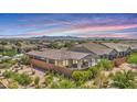 An aerial perspective showcases a fenced backyard with lush plants and a patio area, set against mountain views at 22515 E Sonoqui Blvd, Queen Creek, AZ 85142