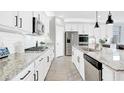 Modern white kitchen features stainless steel appliances, granite countertops, and a subway tile backsplash at 22515 E Sonoqui Blvd, Queen Creek, AZ 85142