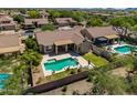 Backyard oasis features a sparkling pool, covered patio, and beautifully landscaped yard at 4010 E Hamblin Dr, Phoenix, AZ 85050