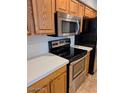 The kitchen features stainless steel appliances, wood cabinets, and solid surface countertops at 4202 E Broadway Rd # 223, Mesa, AZ 85206