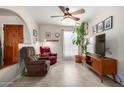 Cozy living room features tile floors, neutral walls, natural lighting, ceiling fan, and a large TV at 5580 W Kesler St, Chandler, AZ 85226