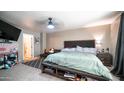 Spacious bedroom with a bed, side table, and additional seating area at 7274 W State Ave, Glendale, AZ 85303