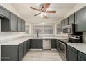 Well-lit kitchen featuring gray cabinetry, stainless steel appliances, and large bay window at 8668 N 107Th Dr, Peoria, AZ 85345