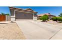 Lovely home featuring a spacious driveway and desert landscaping for easy maintenance at 10342 E Obispo Ave, Mesa, AZ 85212
