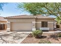 Home exterior featuring neutral paint, tile roof, and two-car garage at 13020 W Highland Ave, Litchfield Park, AZ 85340