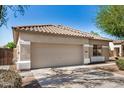 Home exterior showcasing garage door, neutral paint, tile roof, and desert landscaping at 13020 W Highland Ave, Litchfield Park, AZ 85340