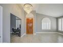 Bright foyer featuring a chandelier, wood door, and views into an adjacent room with plantation shutters at 14039 S 33Rd Way, Phoenix, AZ 85044