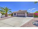 Attached two-car garage with extended driveway and secure gated entry, framed by mature landscaping at 14039 S 33Rd Way, Phoenix, AZ 85044