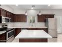 Stylish kitchen with stainless steel appliances, quartz countertops, and dark cabinetry at 2000 N 36Th St # 19, Phoenix, AZ 85008