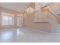 Bright and spacious living room featuring tile floors, staircase, and a chandelier at 20277 N 68Th Dr, Glendale, AZ 85308