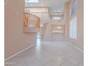 Open-concept living room featuring a high ceiling, tile floors, and an open staircase at 20277 N 68Th Dr, Glendale, AZ 85308