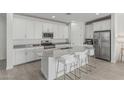 Bright kitchen features white cabinets, gray countertops, stainless steel appliances, and a large island with seating at 23068 E Stacey Rd, Queen Creek, AZ 85142