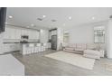 Open-concept living space features a white sofa, a white rug, and connects seamlessly to a modern kitchen at 23068 E Stacey Rd, Queen Creek, AZ 85142