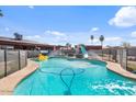 Sparkling backyard pool with slide, fun inflatables, and a secure safety fence perfect for Gathering enjoyment at 2319 N 71St Dr, Phoenix, AZ 85035
