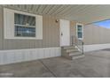 View of the property's entrance featuring a large carport, white door, and small porch with steps at 320 E Mckellips Rd # 245, Mesa, AZ 85201