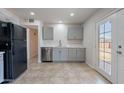 Modern kitchen with stainless steel appliances, gray cabinets, and door to back at 3423 W Bloomfield Rd, Phoenix, AZ 85029