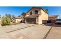 A two-story single-Gathering home with desert landscaping and a large driveway with a two-car garage at 3619 N 104Th Dr, Avondale, AZ 85392