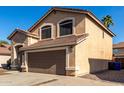 Two-story home featuring a two-car garage, arched windows, and a low-maintenance desert landscape at 3619 N 104Th Dr, Avondale, AZ 85392