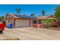 Single-story home with a two-car garage, solar panels, and desert landscaping at 4501 N 60Th Ave, Phoenix, AZ 85033