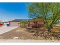 Charming single-story home featuring a two-car garage and desert landscaping with flowering bushes at 4501 N 60Th Ave, Phoenix, AZ 85033