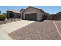 View of a single-story home with a two-car garage and a gravel front yard at 5437 W Bluefield Ave, Glendale, AZ 85308