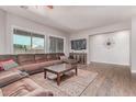 Spacious living room with hardwood floors, large sectional, TV, and a stylish accent wall at 557 S Lemon Ct, Gilbert, AZ 85296
