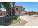 A two-story home with a three-car garage, landscaped front yard, and neutral colored paint at 5744 E Jacaranda St, Mesa, AZ 85205