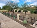 Charming home featuring a brick facade, arched entryways, desert landscaping, and a decorative wrought iron fence at 5801 N 73Rd Ave, Glendale, AZ 85303