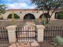 The home features a brick facade, arched entryways, desert landscaping, and a decorative wrought iron fence at 5801 N 73Rd Ave, Glendale, AZ 85303