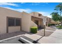 Beige home showcasing well-maintained landscaping, visitor parking, and a desert aesthetic at 5813 W Gelding Dr, Glendale, AZ 85306