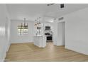 Bright living space with open floor plan featuring modern light fixtures and seamlessly flowing into the upgraded kitchen at 7137 N 22Nd Dr, Phoenix, AZ 85021
