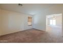 Spacious living room with neutral carpet, a window with blinds, and open access to other rooms at 1336 E Laurel Pl, Casa Grande, AZ 85122
