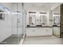Modern bathroom featuring dual sinks, granite countertops, and walk-in shower at 1409 E Goldenrod St, Phoenix, AZ 85048