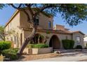 Charming two-story home showcasing mature landscaping, terracotta tile roof, and an arched entryway at 16178 W Granada Rd, Goodyear, AZ 85395