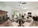 Open-concept dining area featuring a glass table, a fireplace, and an adjacent living space at 2059 E Brown Rd # 35, Mesa, AZ 85213