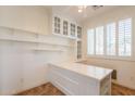Bright home office featuring built-in desk, shelves, and natural light from shuttered window at 22993 W Micah Way, Buckeye, AZ 85326