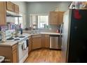 A functional kitchen includes wood cabinets, white appliances, and stainless steel dishwasher and sink at 2311 E Hartford Ave # 38, Phoenix, AZ 85022