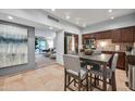 Dining area with tile floors, a view into the living room, and a kitchen with wood cabinets at 357 E Thomas Rd # A208, Phoenix, AZ 85012