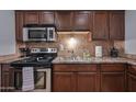 Updated kitchen features stainless steel appliances, tile backsplash, and wood cabinets at 357 E Thomas Rd # A208, Phoenix, AZ 85012